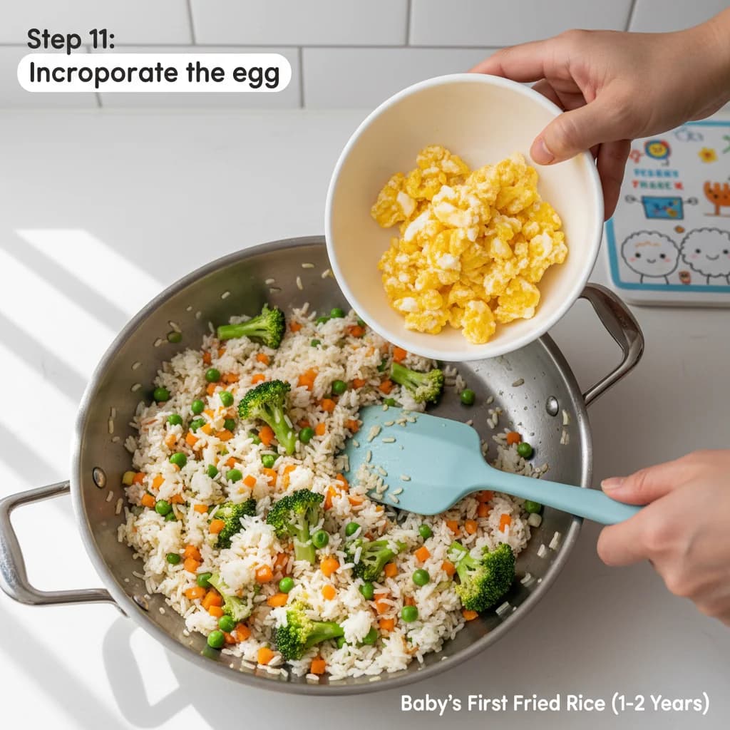 Step 11: Incorporate the egg: Add the scrambled egg back into the pan with the rice and vegetables. for Baby's First Fried Rice (Egg & Veggie)